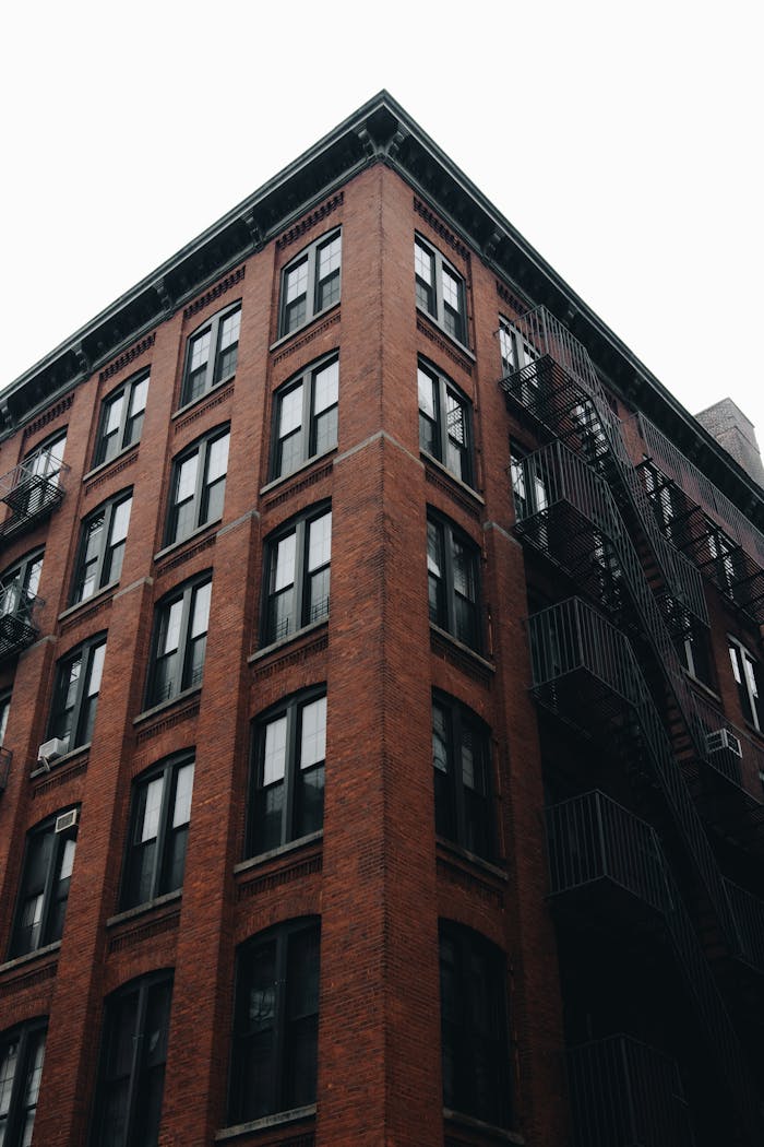A classic New York City brick building with fire escapes, showcasing urban architecture.